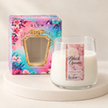 Midnight Latte Perfumer candle in a rounded clear glass jar with rose label, cream wax and floral gift box on an ivory plinth